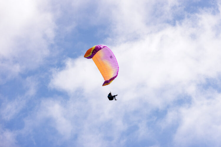 Paraglider flying in blue sky